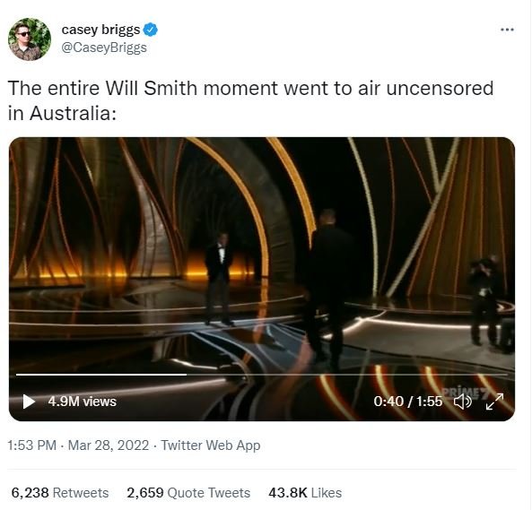 A screenshot of a Twitter feed with the caption The entire Will Smith moment went to air uncensored in Australia: above a horizontal video of two men in suits on an opulent stage, the one advancing from the stage slapping the other