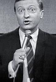 A picture of Graham kennedy, an older white man holding a microphone