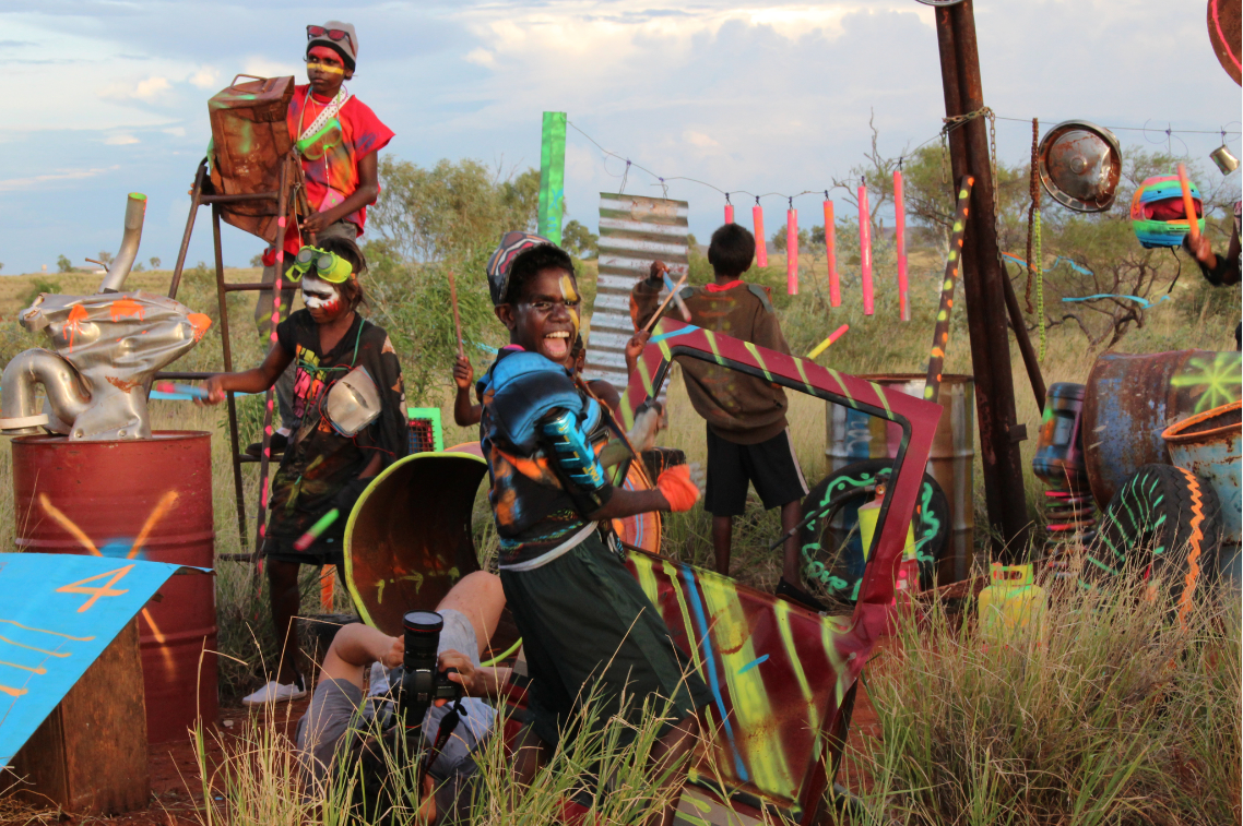 A group of children dressed up as space age astronauts against a desert background