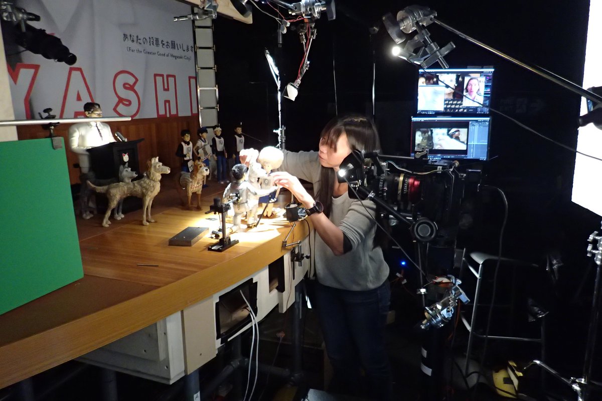 A picture of a woman working in a model shop, handling the small dog puppets for Isle of Dogs