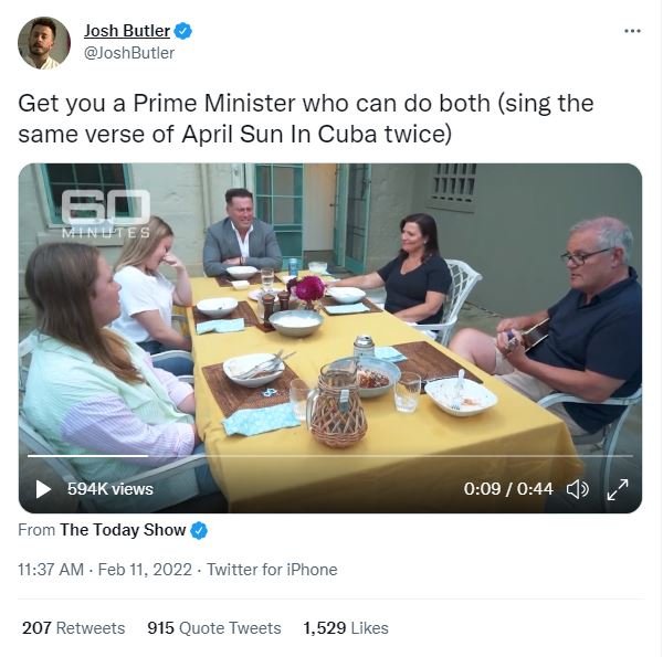 A Tweet showing Scott Morrison playing the ukulele in a blue shirt at a table with a yellow cloth, his wife Jenny sits to his left and Karl Stefanovic watches from the head of the table. His two teen daughters look embarrassed.