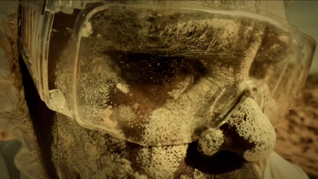 A close up of someone's face covered with white makeup and protective glasses