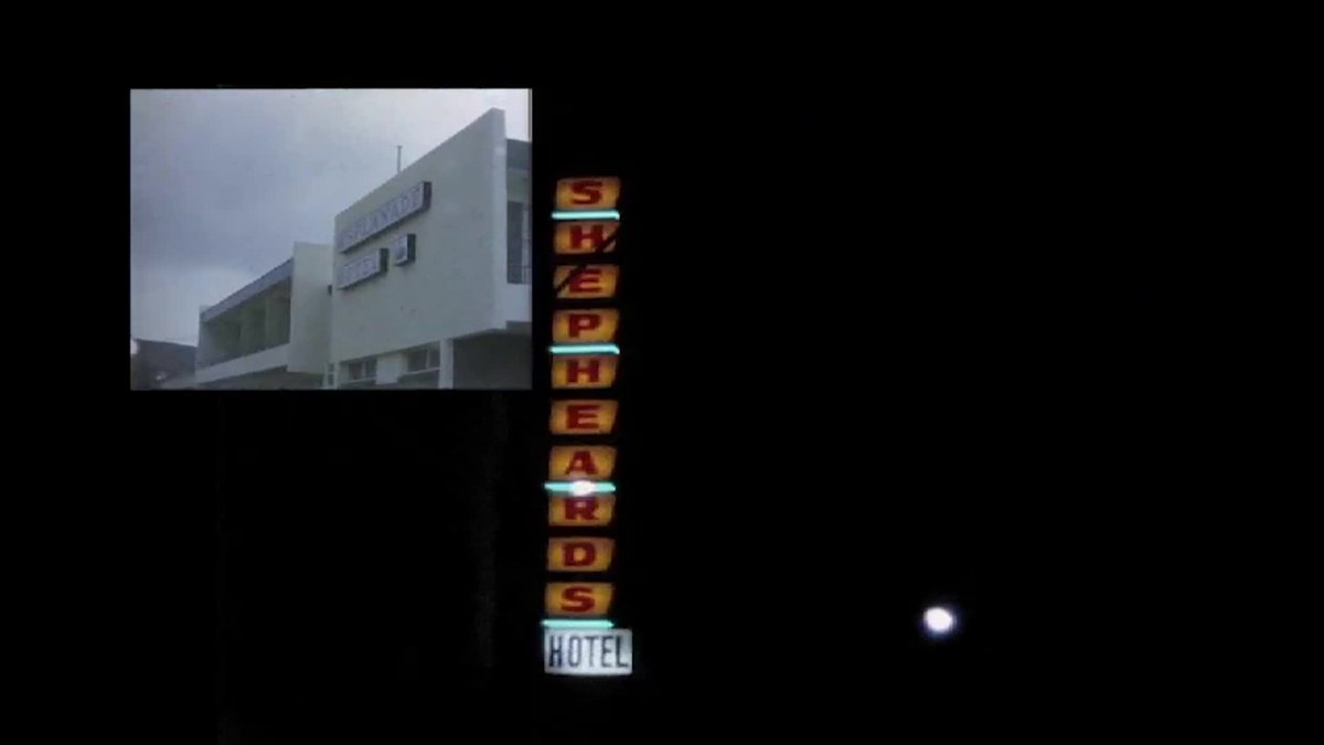 An image of a hotel at night with the sign reading Shepherds lit up in orange and red